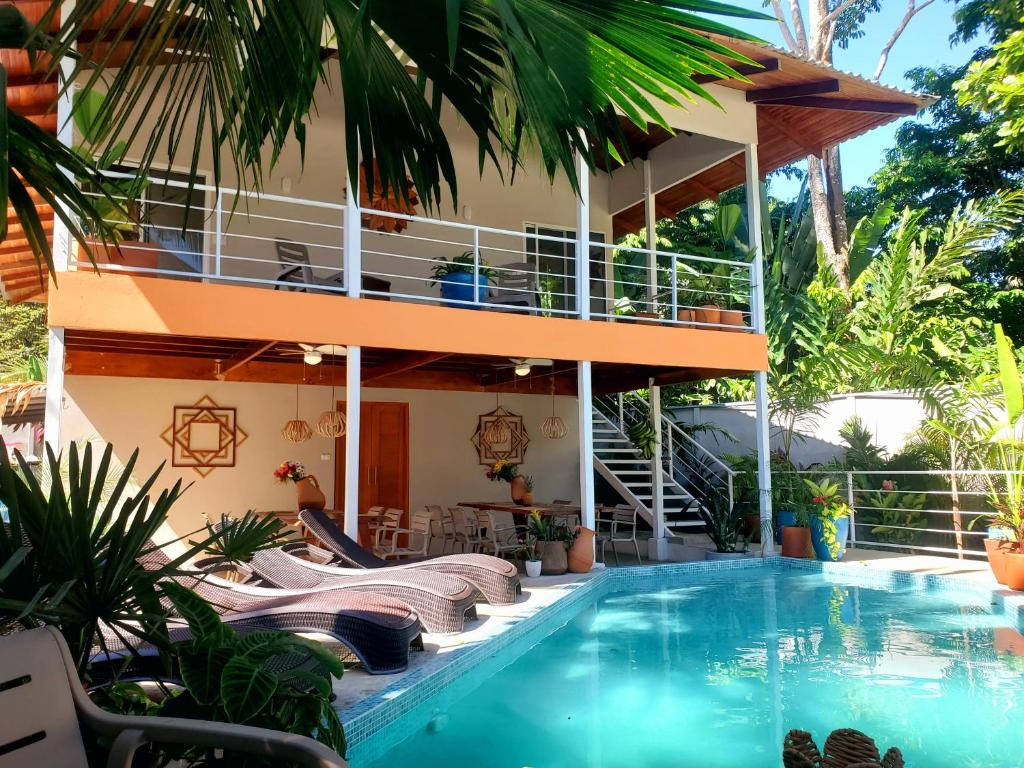 a villa with a swimming pool in front of a house at Sanctuary Puerto Viejo in Cocles