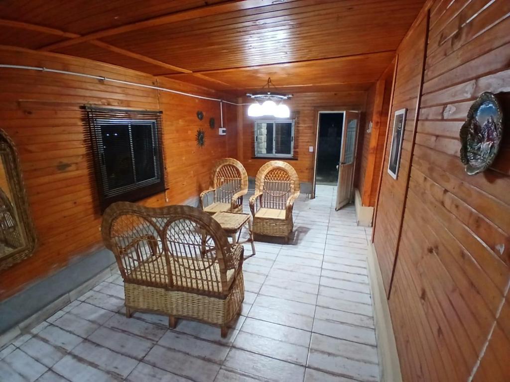 a hallway with wicker chairs and a table in a house at Hospedaje Abiel in El Mollar