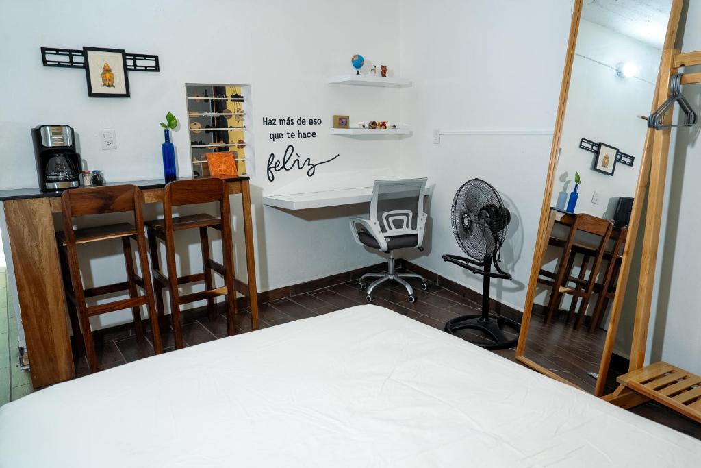a bedroom with a bed and a desk and chairs at Rincón pochutleco in San Pedro Pochutla
