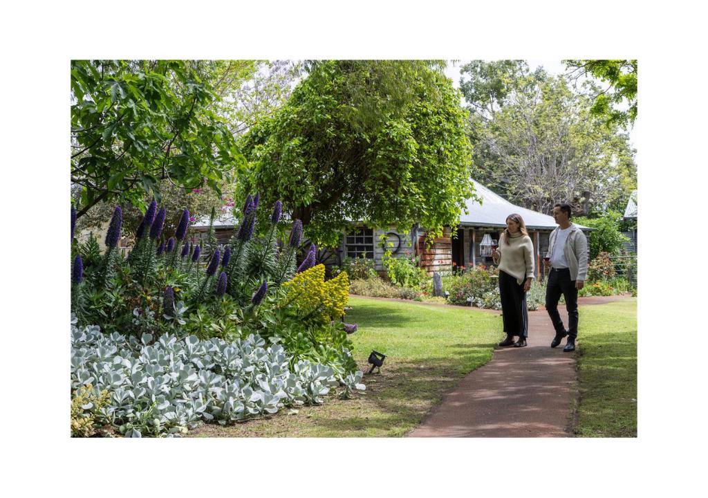 a man and a woman walking through a garden at Rústica Estate in Quindalup