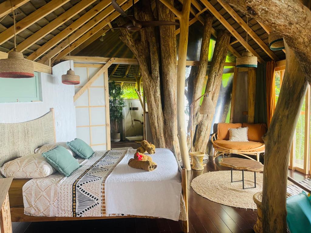 a bedroom with a bed with trees growing out of it at Raiatea Treelodge in Taoru