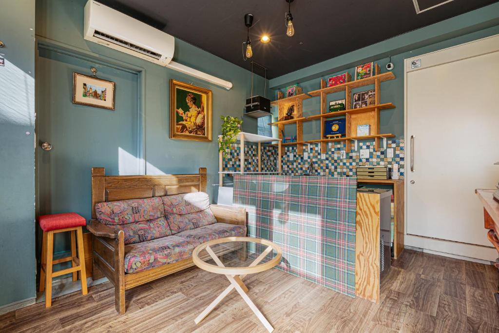 a living room with a couch and a table at Guesthouse YOURS in Osaka