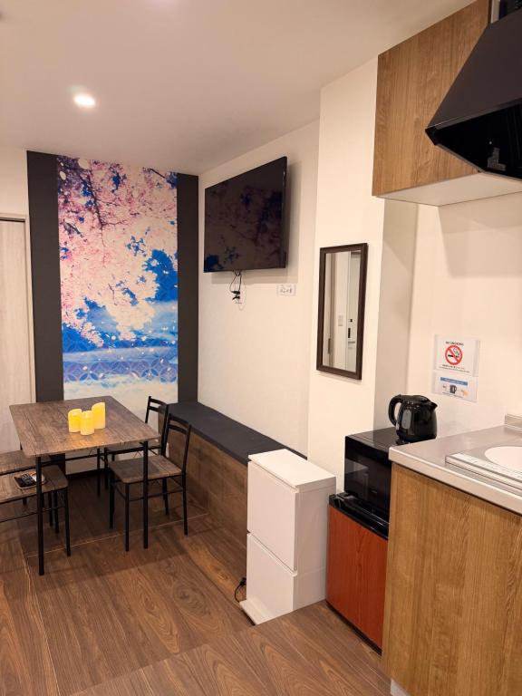 a kitchen with a table and a dining room at 登福桜 動物園前駅4番出口徒歩1秒 通天閣5分 難波駅10分 大阪駅15分 関西空港直通 usj25分 in Osaka