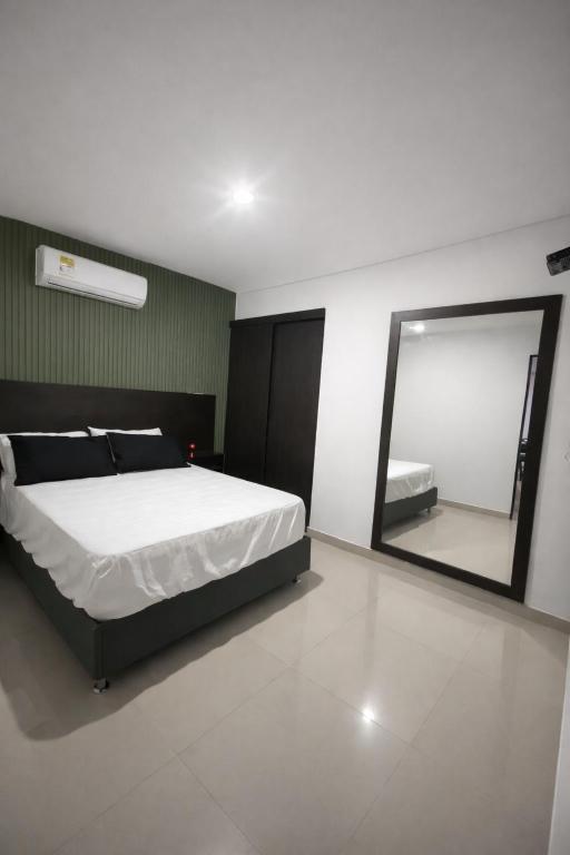 a bedroom with a bed and a large mirror at Inmosolaris in Cali