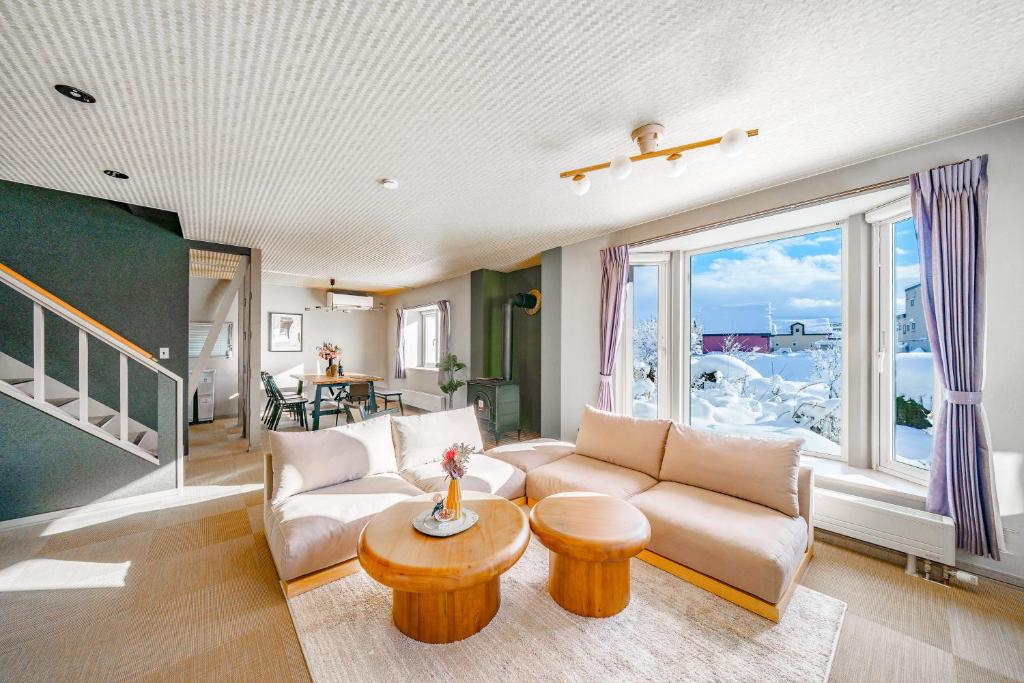a living room with a couch and a table at The Crane Sanctuary Kamifurano in Kami-furano