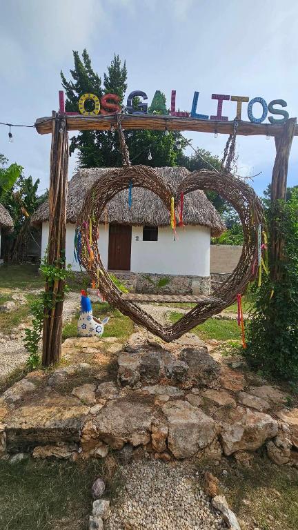 a heart shaped sign in front of a house at Cabaña 2 Los Gallitos Ecolodge in Sacalum