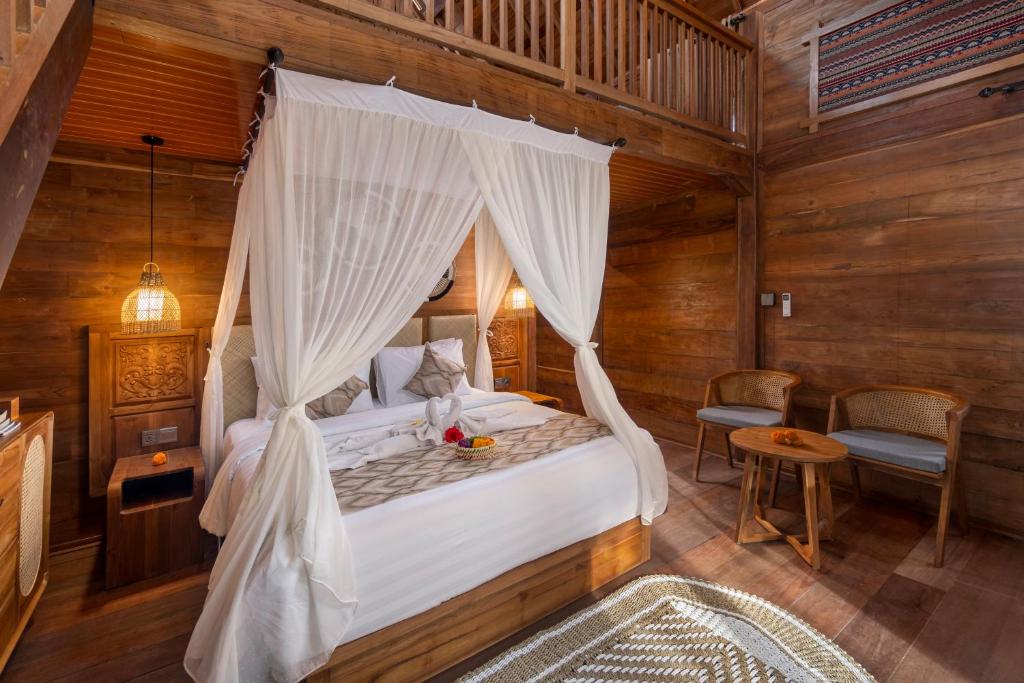 a bedroom with a bed with a canopy at Kirani House - Joglo Villa Bali in Darmasaba
