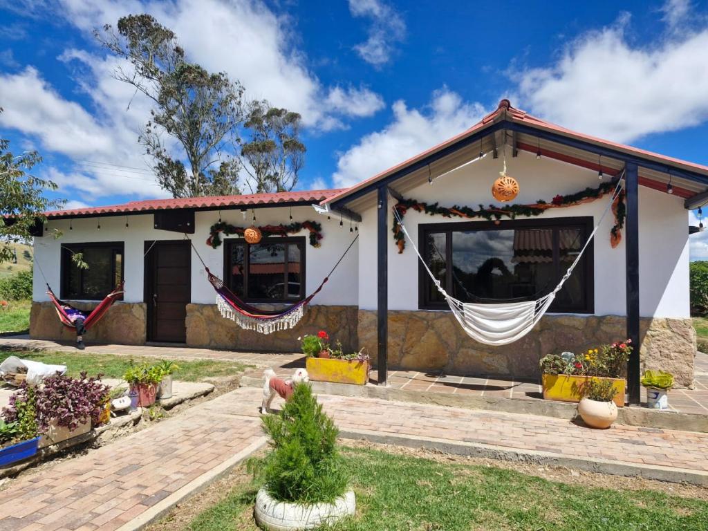 a white house with hammocks in front of it at Villa Alejandra in Quebrada Vieja