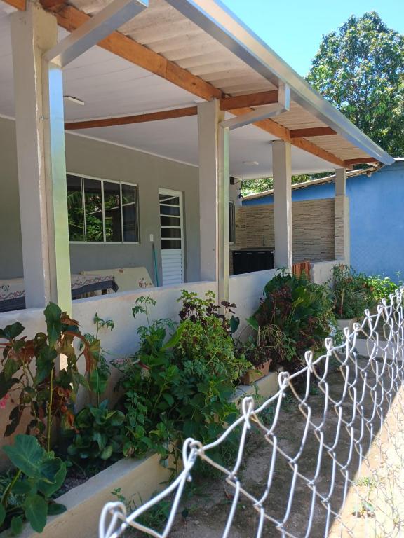 a fence in front of a house with plants at Kitnet na mata atlantica in Ubatuba