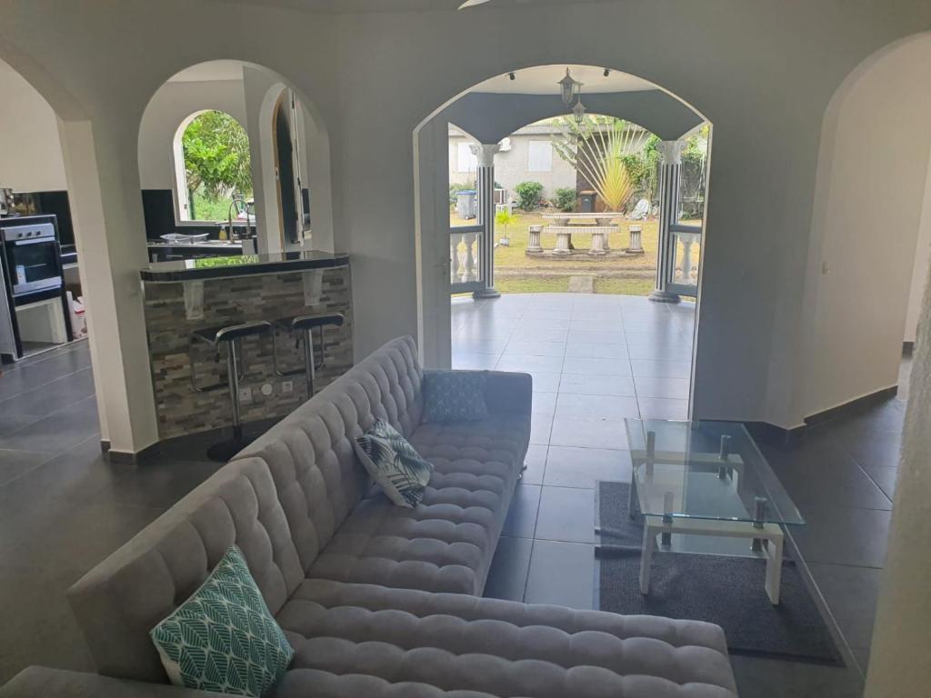 a living room with a couch and a glass table at Villa familiale pensé pour vous in Les Abymes
