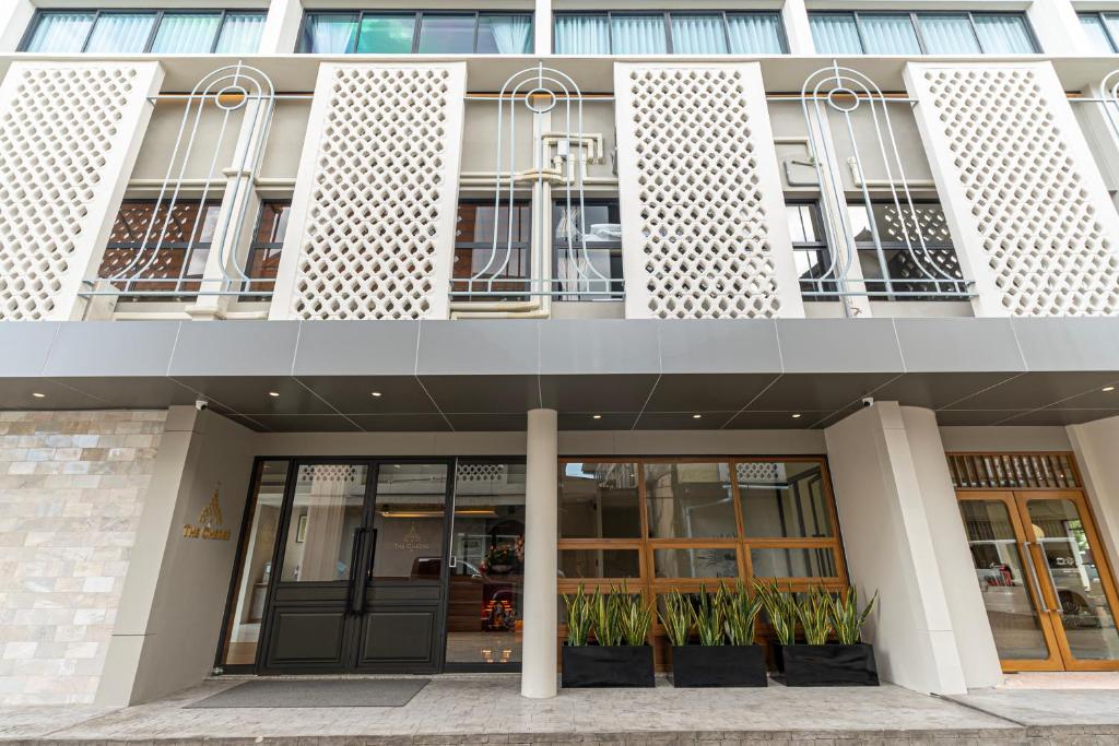 a building with doors and plants in front of it at The Chedee Krungthep in Bangkok