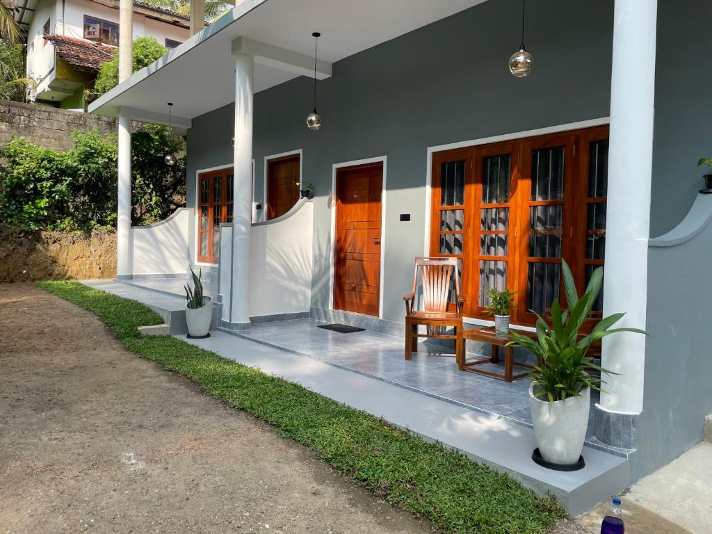 a house with an orange door and a bench on a porch at The BLISS Mihiripenna in Talpe