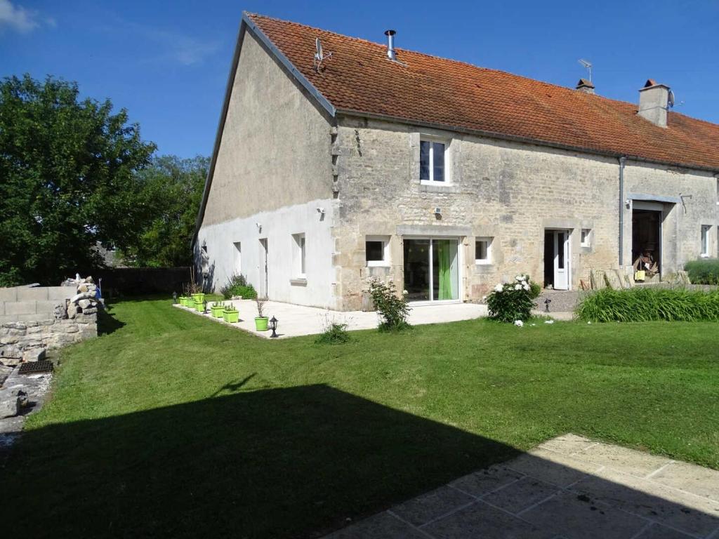 a large stone house with a grass yard at L'étable aux deux noix in Arc-en-Barrois