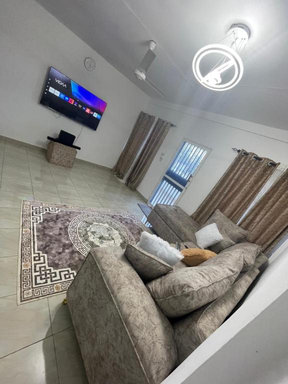 a living room with a couch and a flat screen tv at Ailynes in Diani Beach