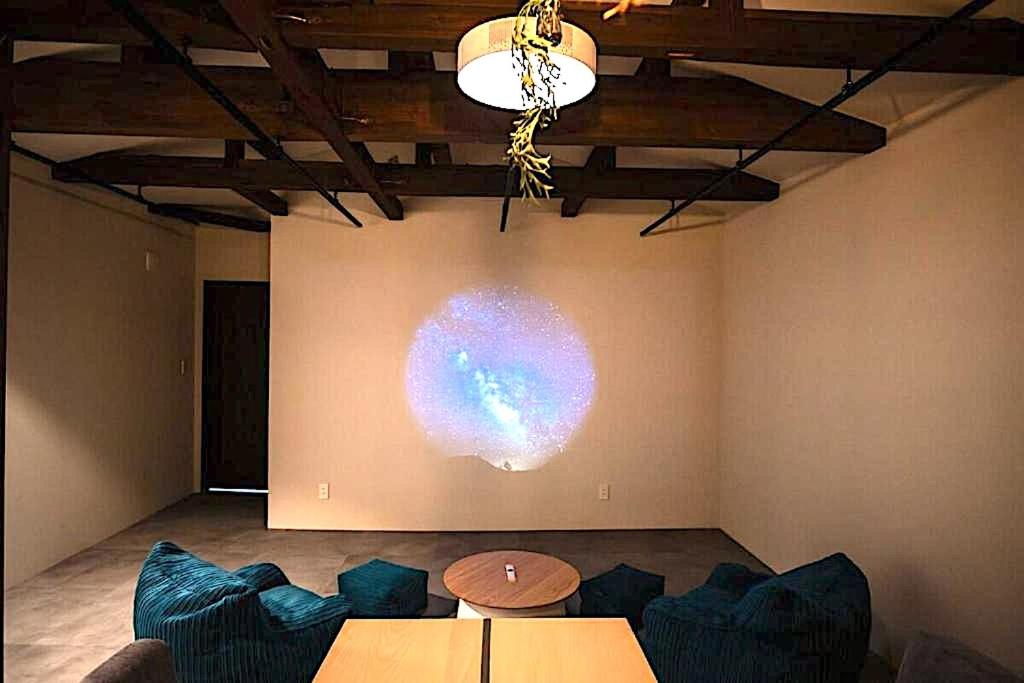 a room with a stage with couches and a table at 将 -show- in Fujiyoshida