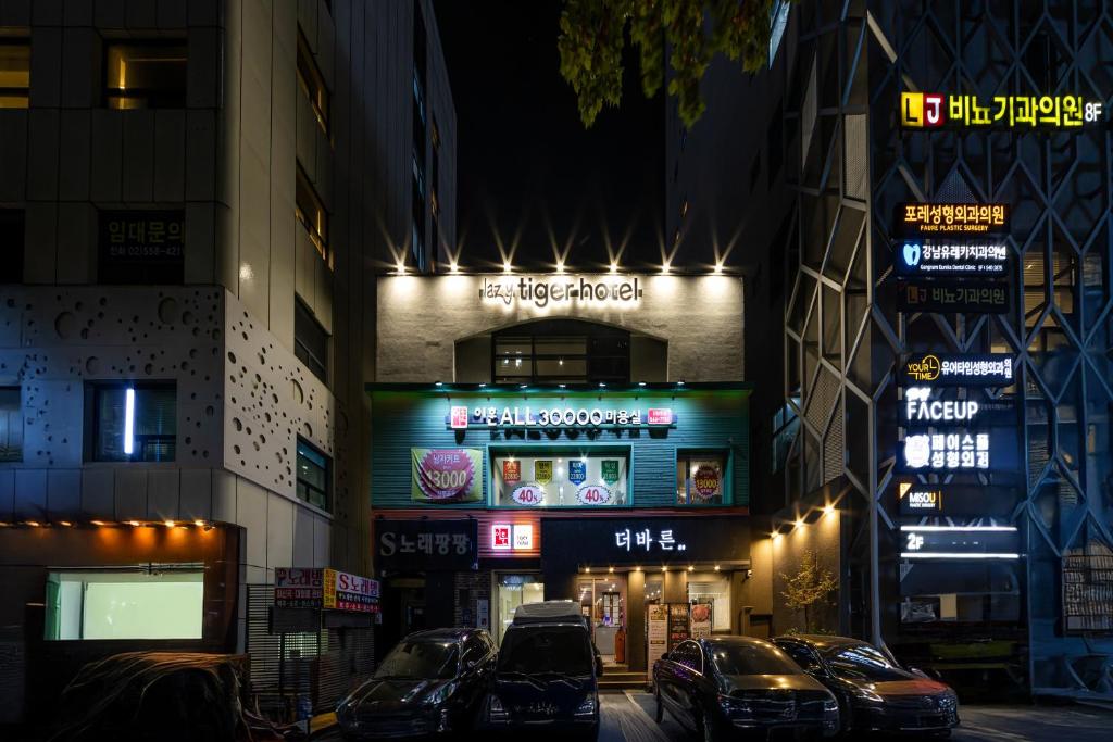 a building with cars parked in front of it at night at lazy tiger hotel in Seoul