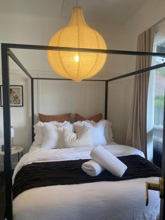 a bedroom with a bed with a chandelier above it at Elegant 3br Haven with Character & Charm in Yarram