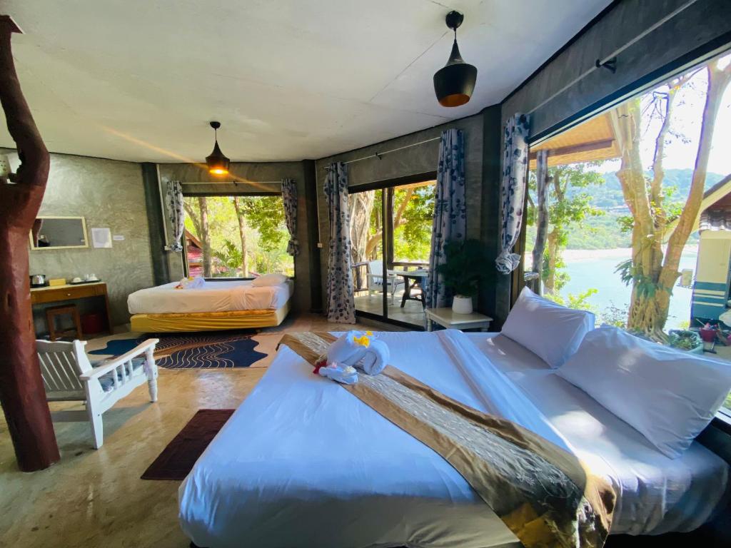 a bedroom with a large bed with a large window at Family view A4 -Kantiang paradise resort- in Ko Bu Bu