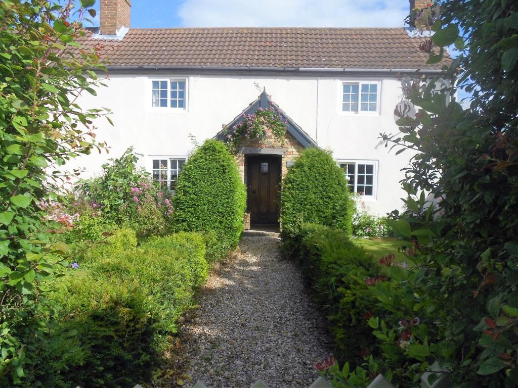 einen Blick auf ein weißes Haus mit einer Tür in der Unterkunft Villa Farm Cottage in Thornton Curtis