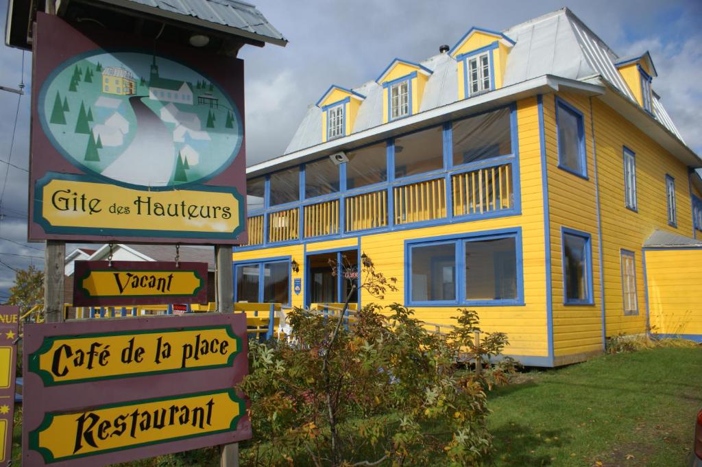 una gran casa amarilla con un cartel delante en Gîte des Hauteurs et Café de la place, en Saint Zenon
