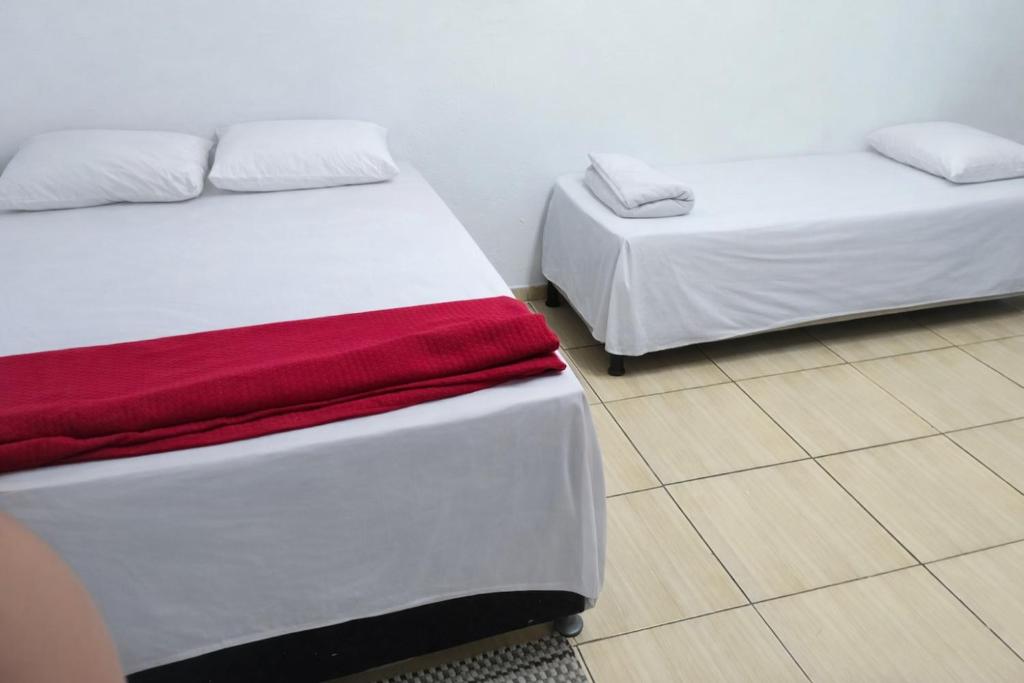 two beds sitting next to each other in a room at Pousada RC Q3 in Várzea Grande