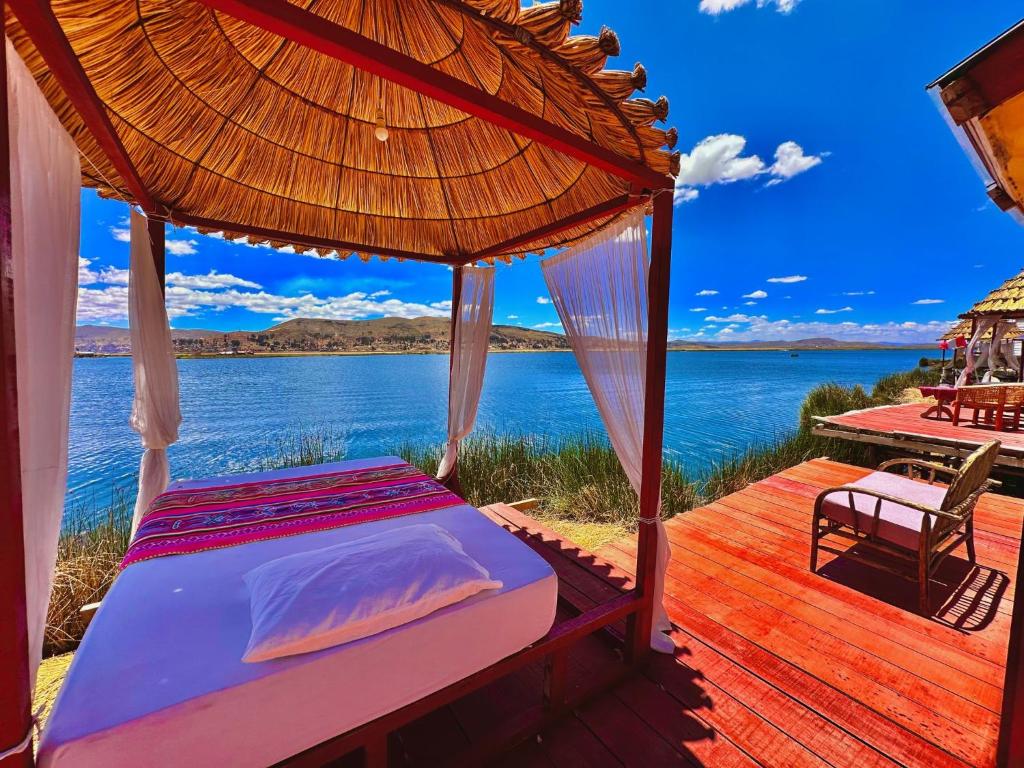 a bed on a deck with a view of the water at Titicaca Samay Lodge Perú in Puno