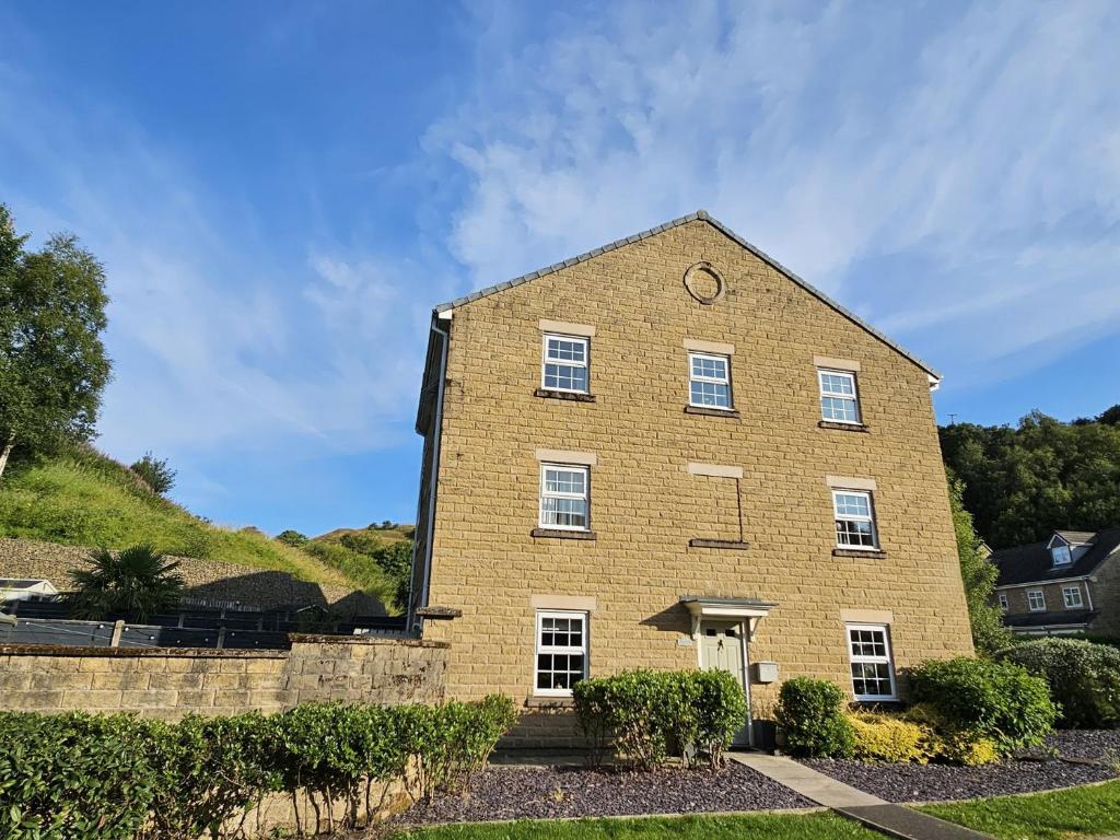 a large brick building with a clock on it at The Milne in Todmorden