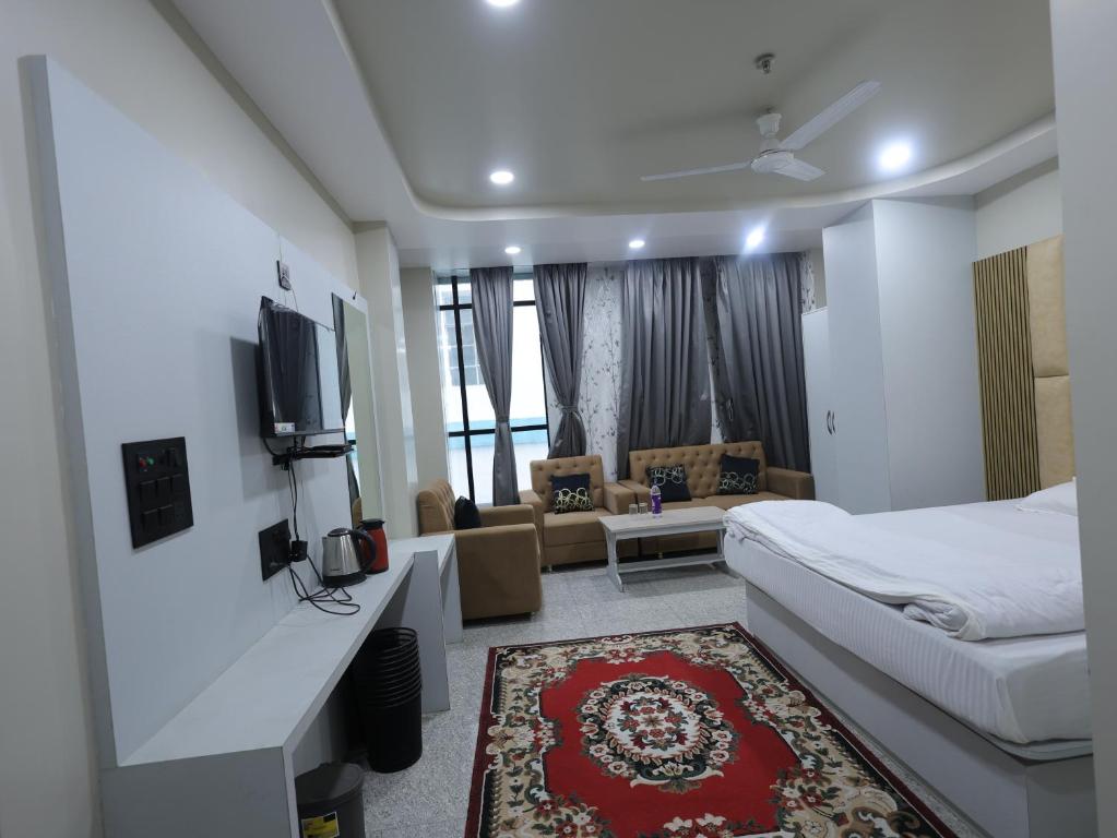 a hotel room with a bed and a tv at Hotel Ganesha - residential in Muzaffarpur