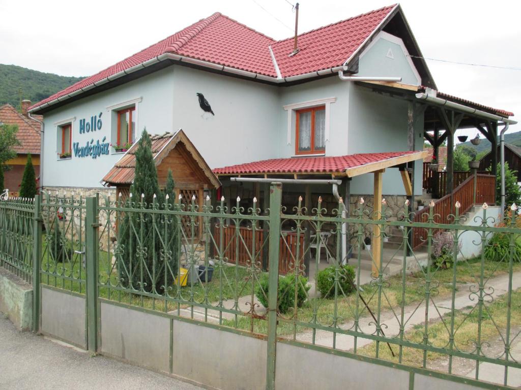 a house with a fence in front of it at Holló Vendégház in Szögliget