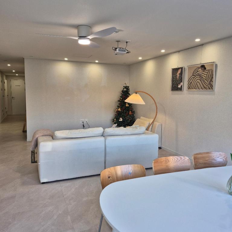 a living room with a couch and a christmas tree at 포포스테이 in Busan