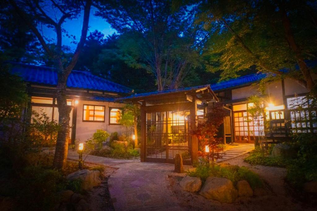 a house at night with lights in front of it at Bessou Konjakuan in Yufu