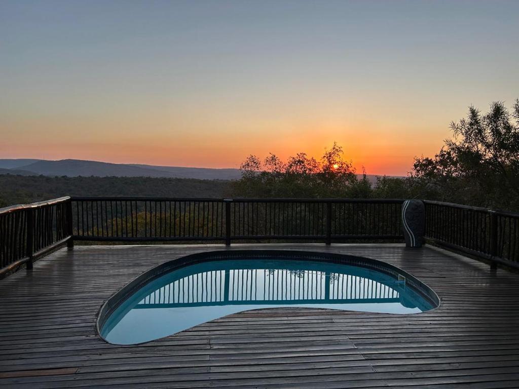 a pool on a deck with the sunset in the background at Luxury Villa at Elements Golf Course - Bela Bela in Warmbaths