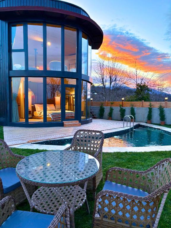 a patio with a table and chairs next to a pool at Dream River Sapanca in Sapanca