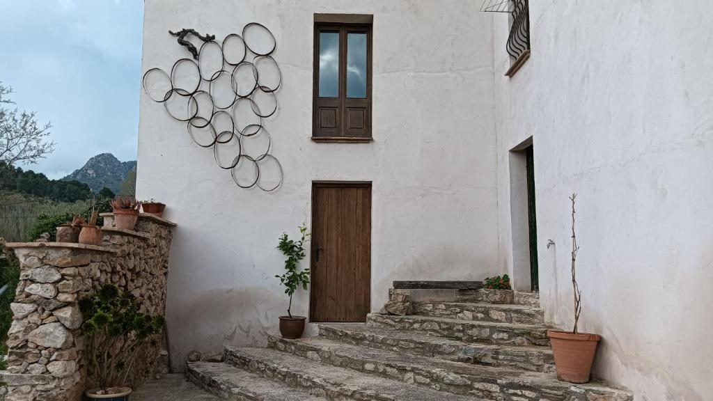 a white building with a door and some stairs at Cal Guixater in Juncosa