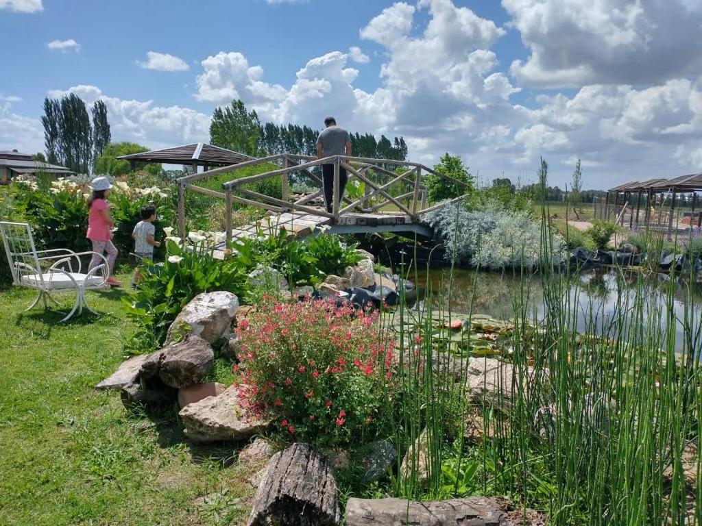 a man walking over a bridge over a pond at Pampas del Sur - Hotel de Campo - Cañuelas in Cañuelas
