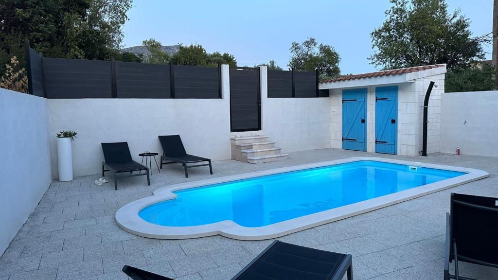 a swimming pool with two chairs and a house at Villa Mendula -Orebic by Villas Guide in Orebić