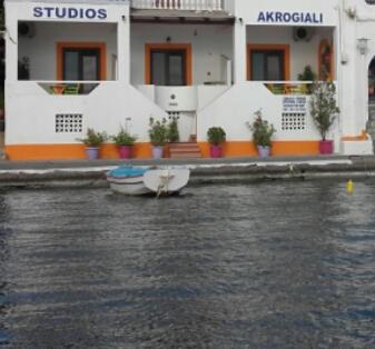 two boats sitting in the water in front of a building at Studios Akrogialli in Lipsoi