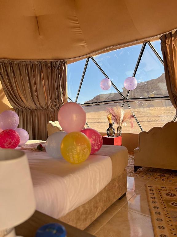 a bed in a room with balloons on it at Wadi Rum Main Road Visitor Center in Disah
