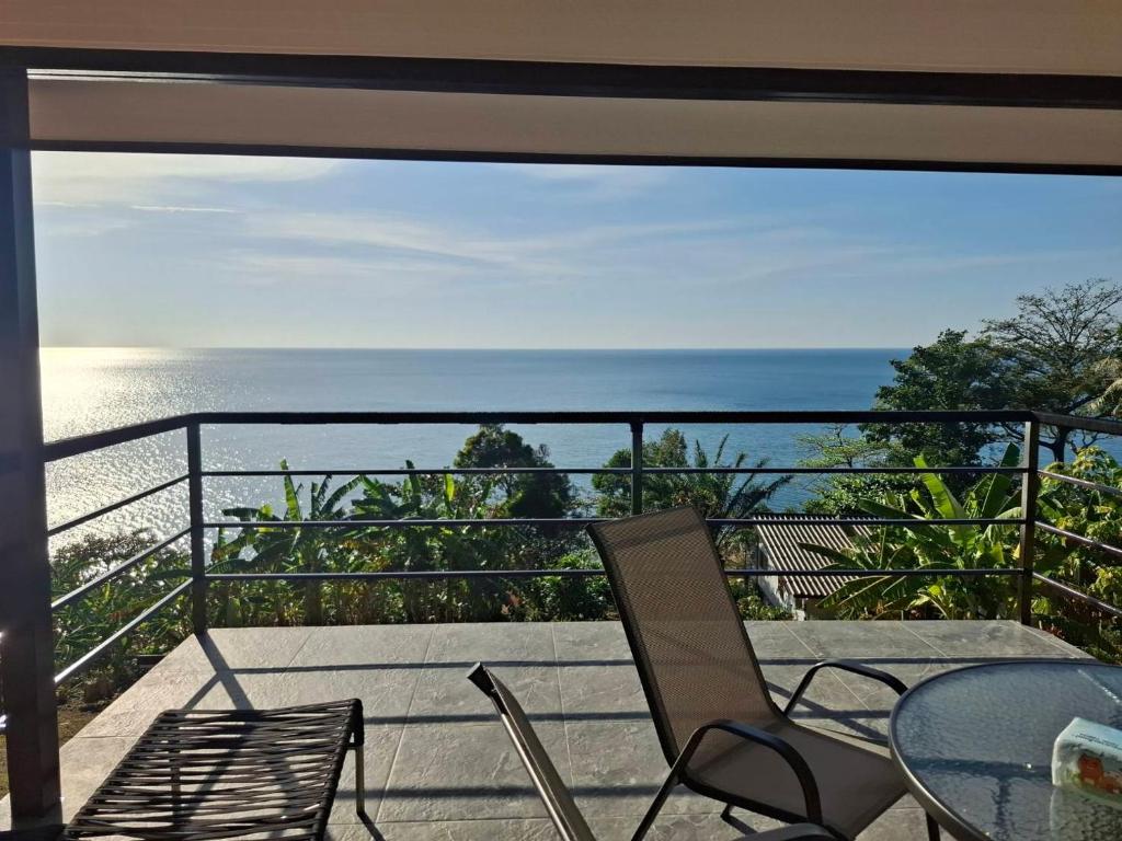 a balcony with a table and chairs and the ocean at Villa Meerblick in Ban Map Khangkhao