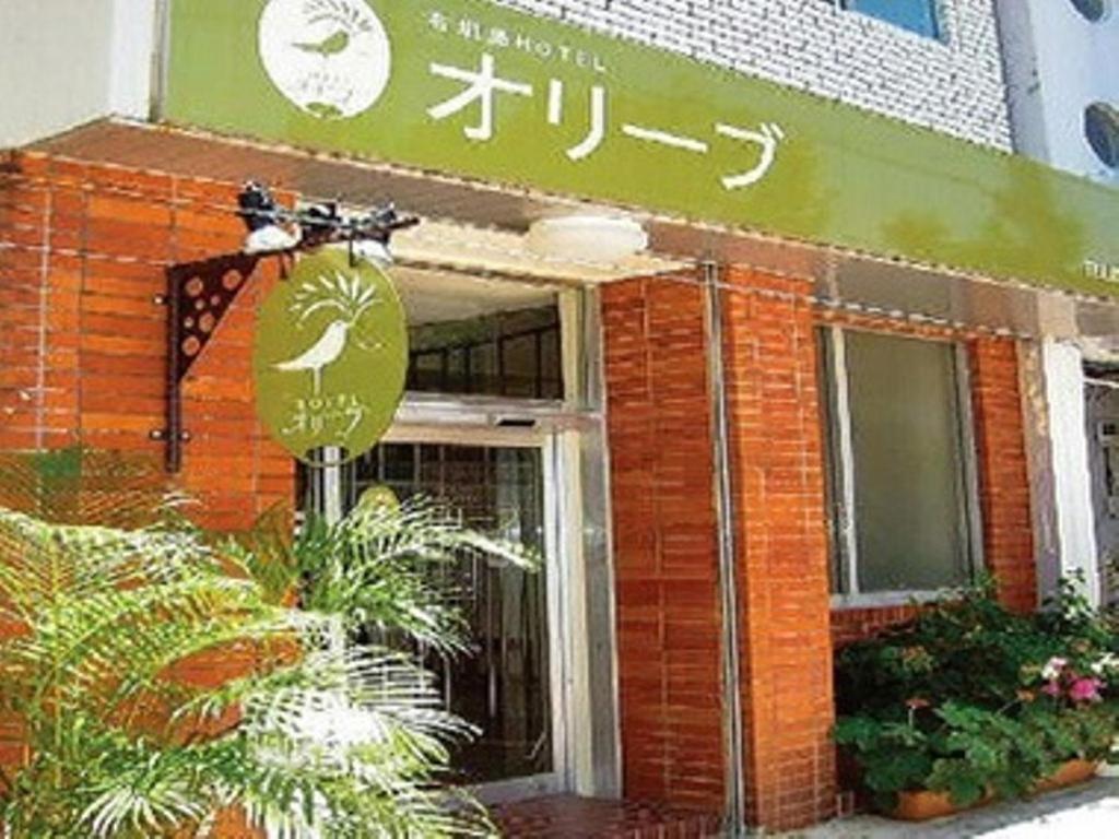un bâtiment avec un panneau à l'avant dans l'établissement Ishigakijima Hotel Olive, à Ishigaki
