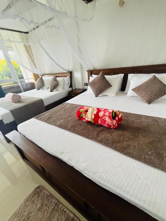 a bedroom with two beds with a flower on the middle at Blissbarn Inn Ella in Ella