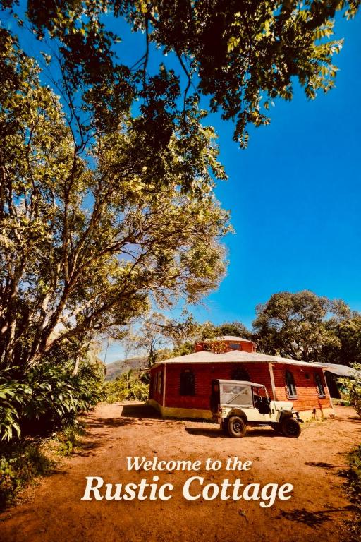 a rv parked in a field with the words welcome to the rusty collective at Westernmagic in Idukki