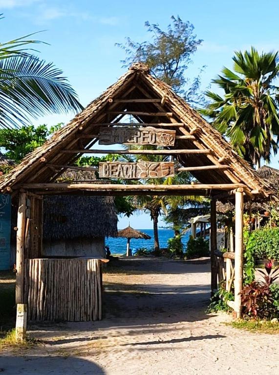 a sign for a hotel with the ocean in the background at Kipepeo Beach and Village in Dar es Salaam