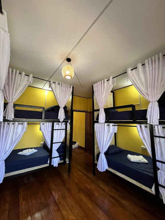 a room with three bunk beds with curtains at Pakse Chill Hostel in Pakse