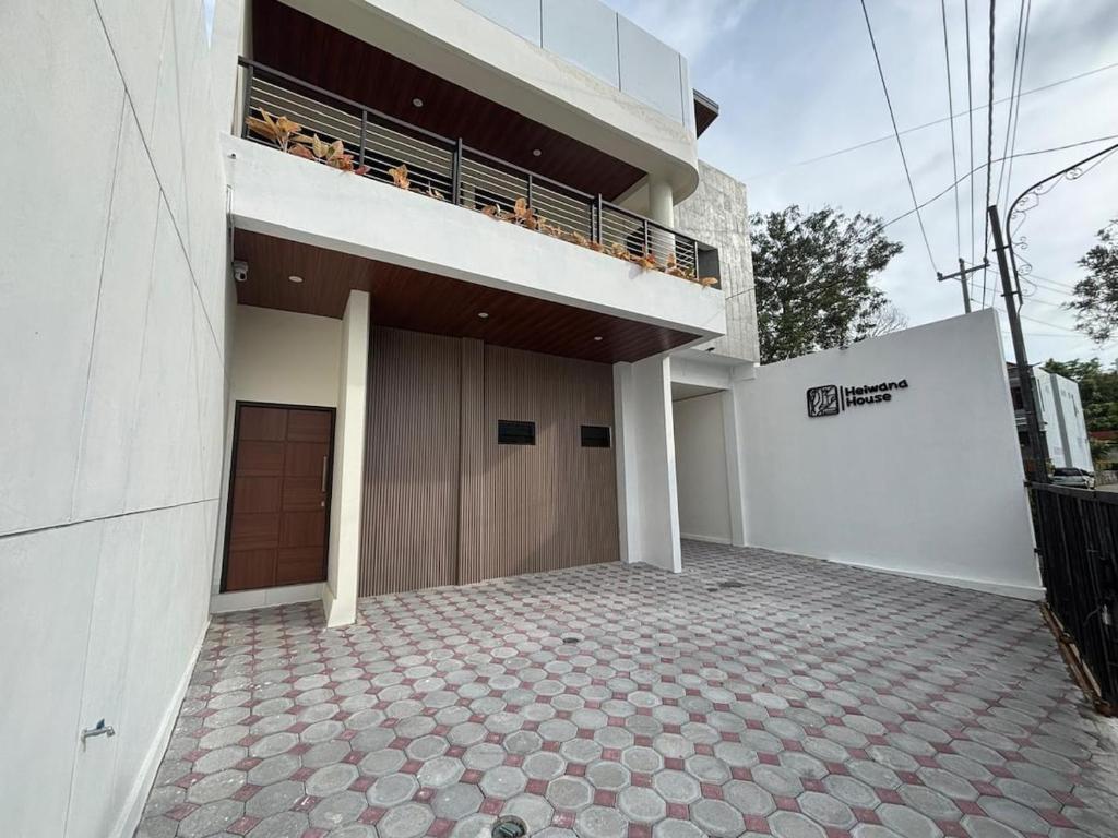 a large building with a balcony on top of it at Heiwana House #1 in Beran-kidul