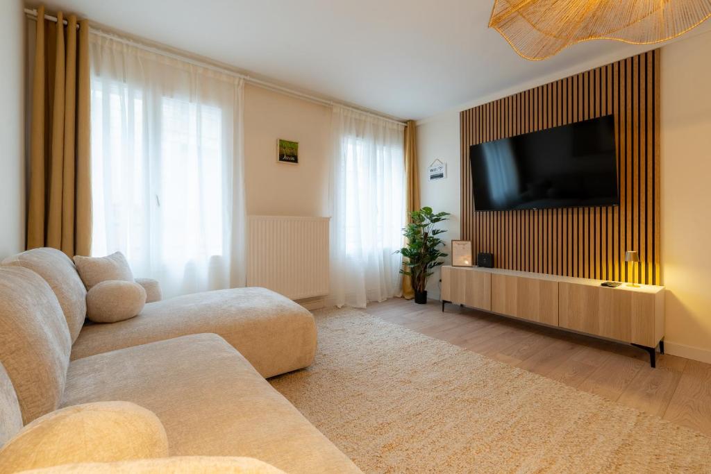 a living room with a couch and a flat screen tv at Harmony in Arras
