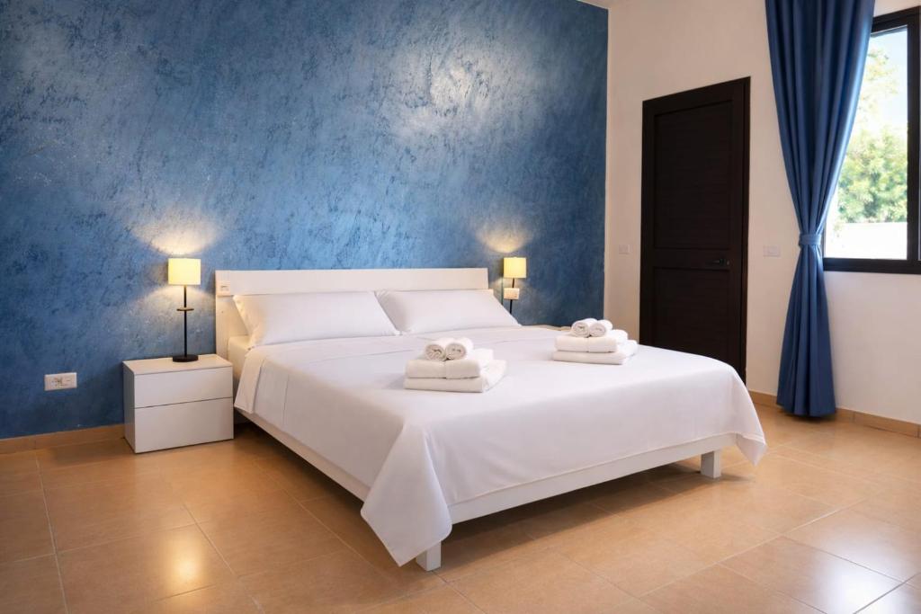 a bedroom with a large white bed with towels on it at B&B Etesia in Pizzo