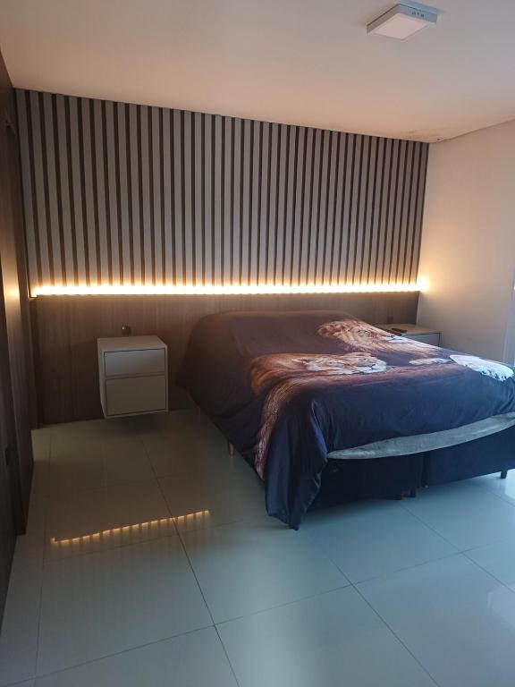 a bedroom with a bed and a wall with a window at Pousada Mineiro in Curitiba