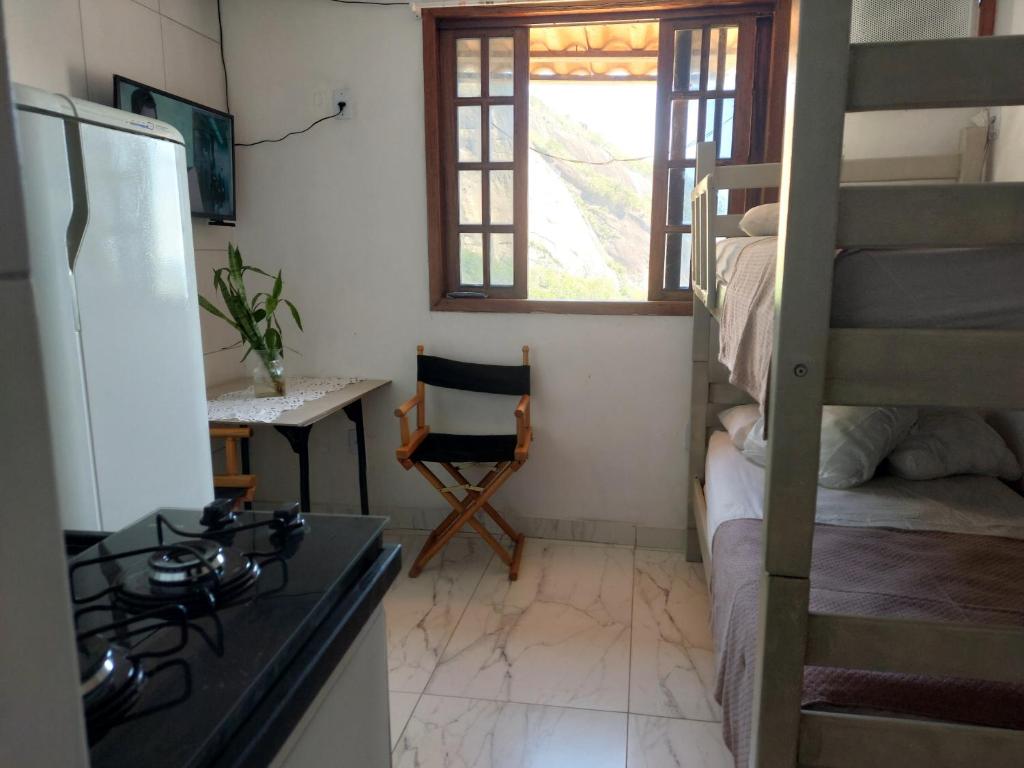 a kitchen with a stove and a bunk bed at Casa da Angela Quarto Triplo in Rio de Janeiro