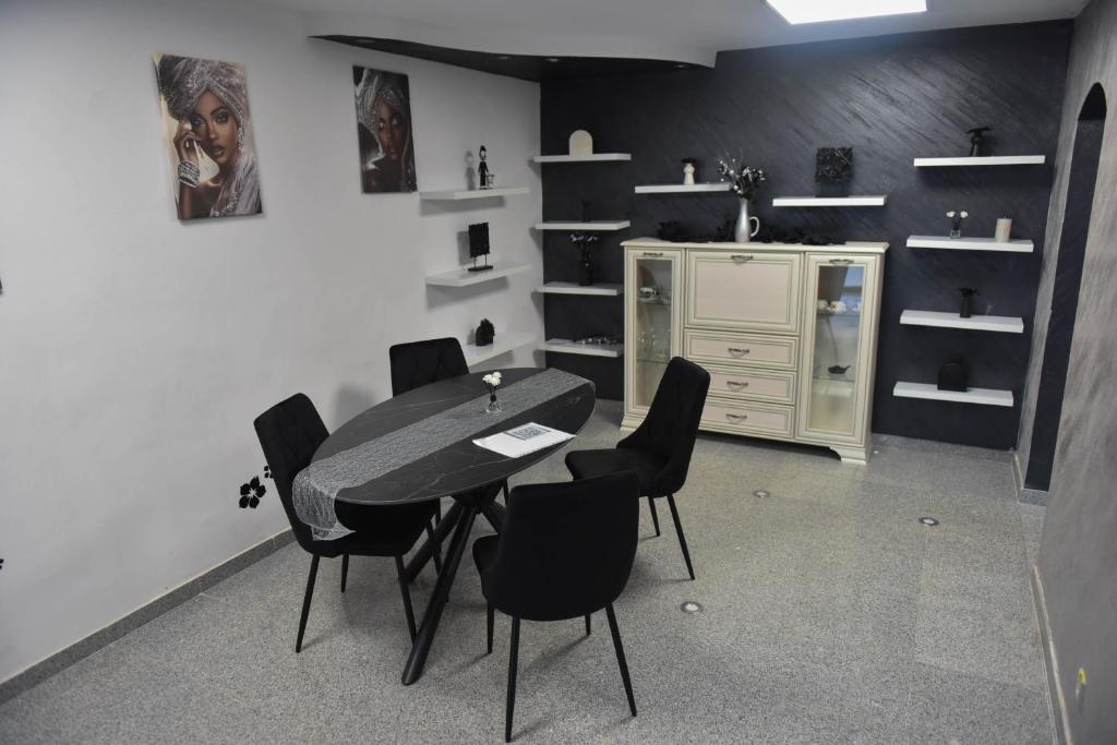 a dining room with a table and black chairs at Glow Sahara in Focşani